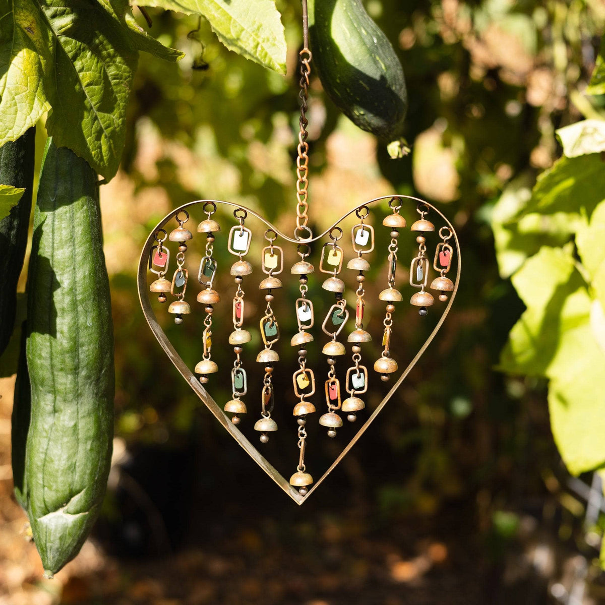 Copper metal heart-shaped wind chime with hanging beaded chains, small bells, and colorful glass beads